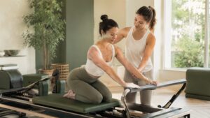 マシンピラティスのリフォーマーで女性トレーナーがマンツーマン指導する様子(Studio NEXTE習得プログラム)