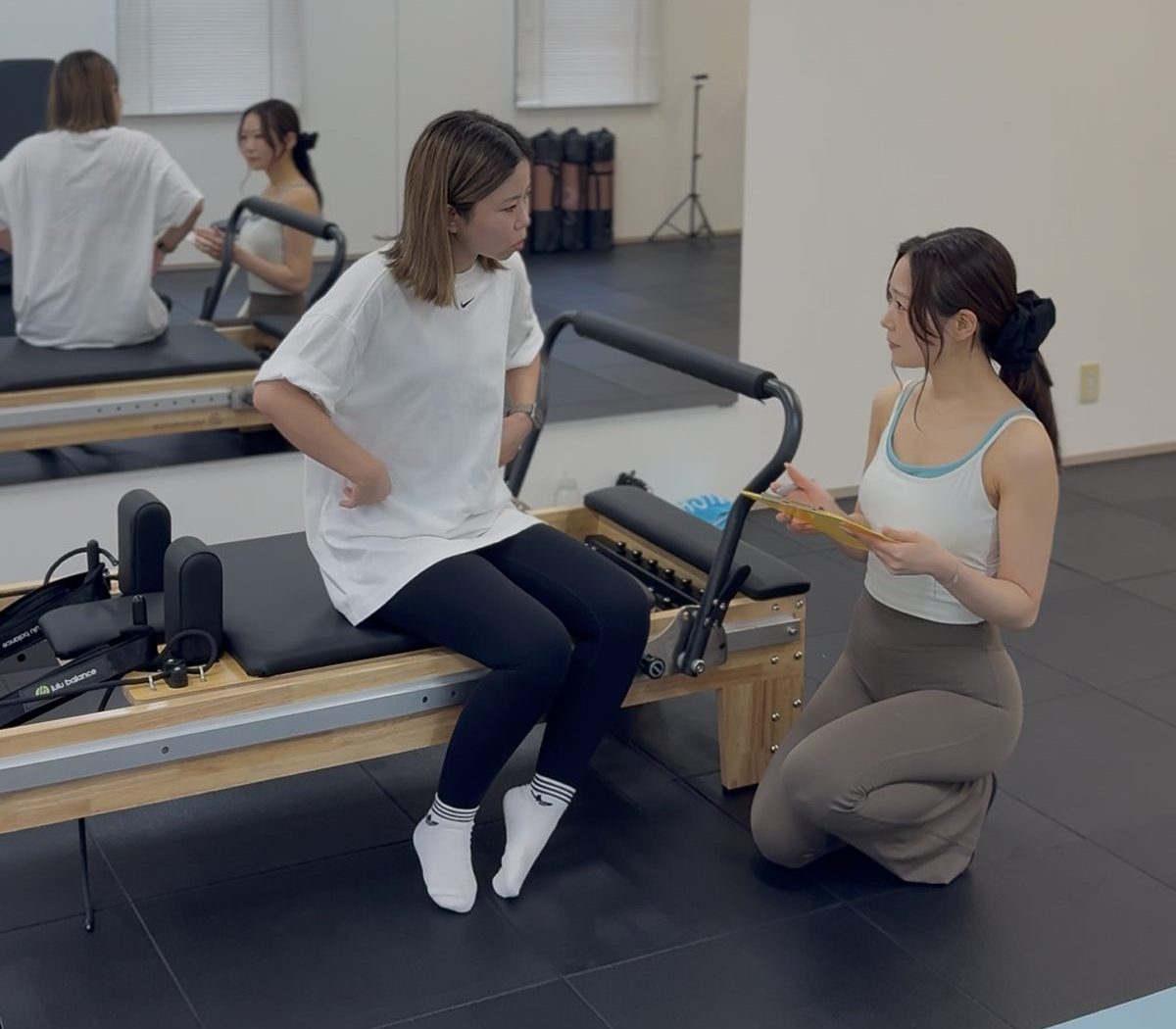Trainer guiding a client on the reformer